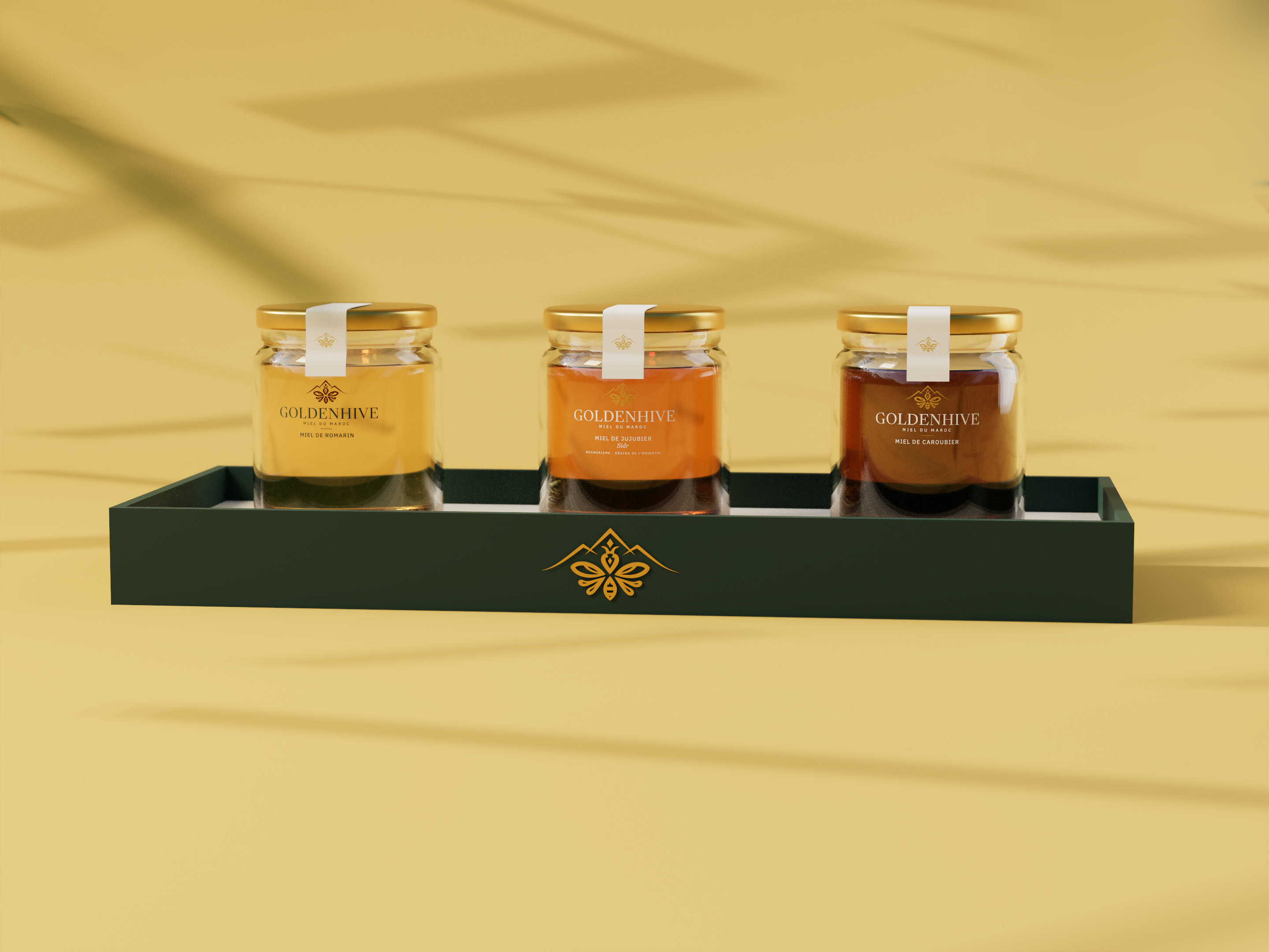 Coffret de trois miels GOLDENHIVE sur un plateau vert